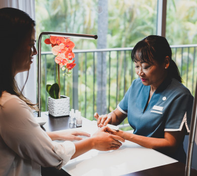 woman enjoying personal nail file manicure in spa