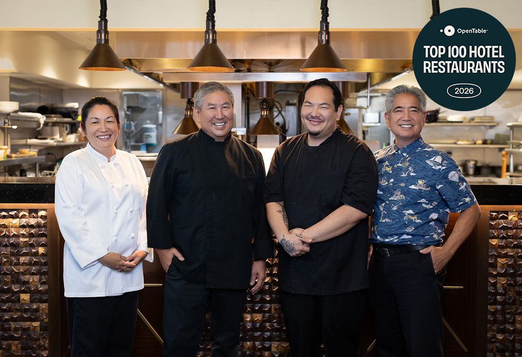 group of chefs standing in front of the kitchen
